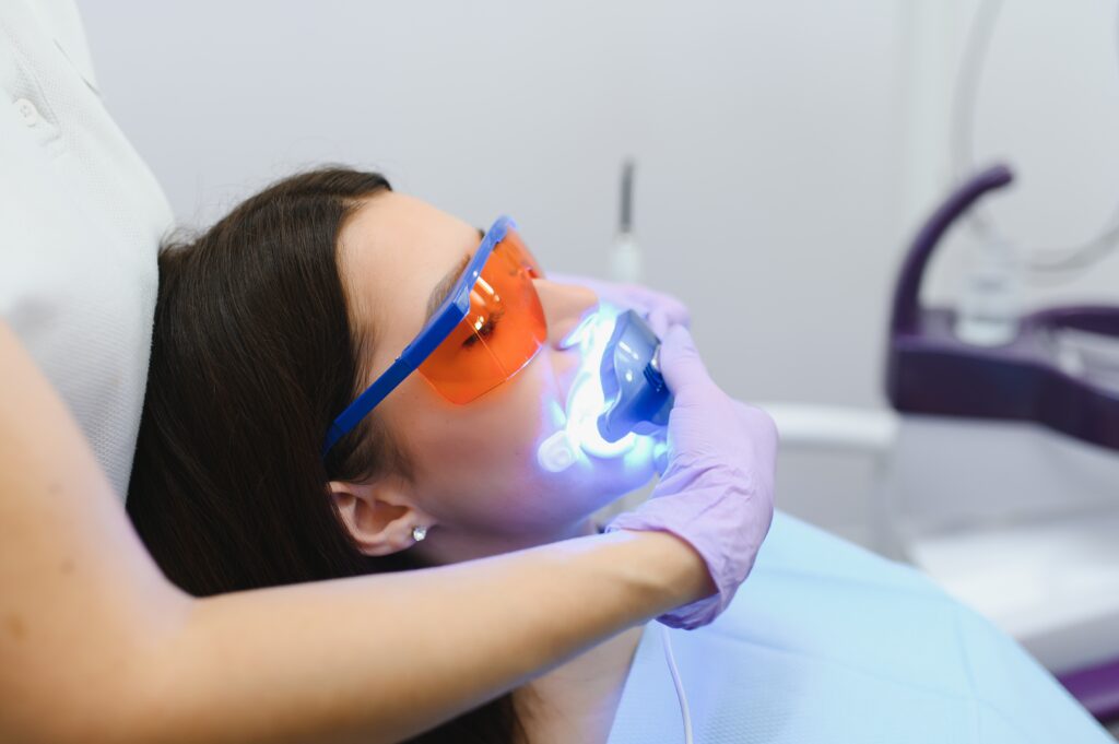 teeth whitening for woman. bleaching of the teeth at dentist clinic.