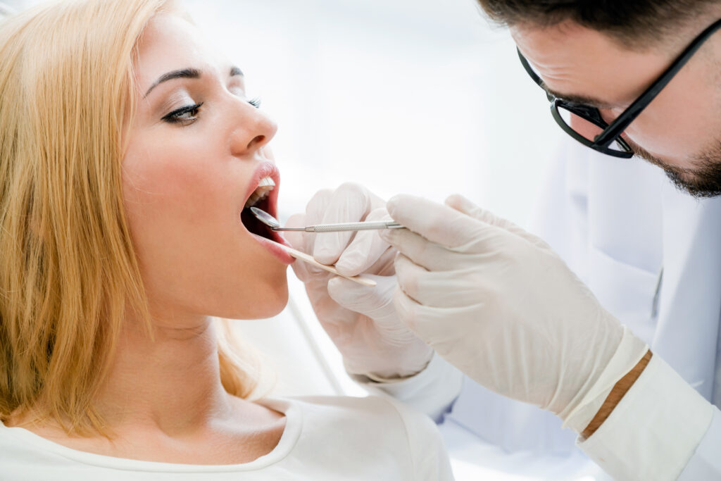 young dentist examining patient in dental clinic.